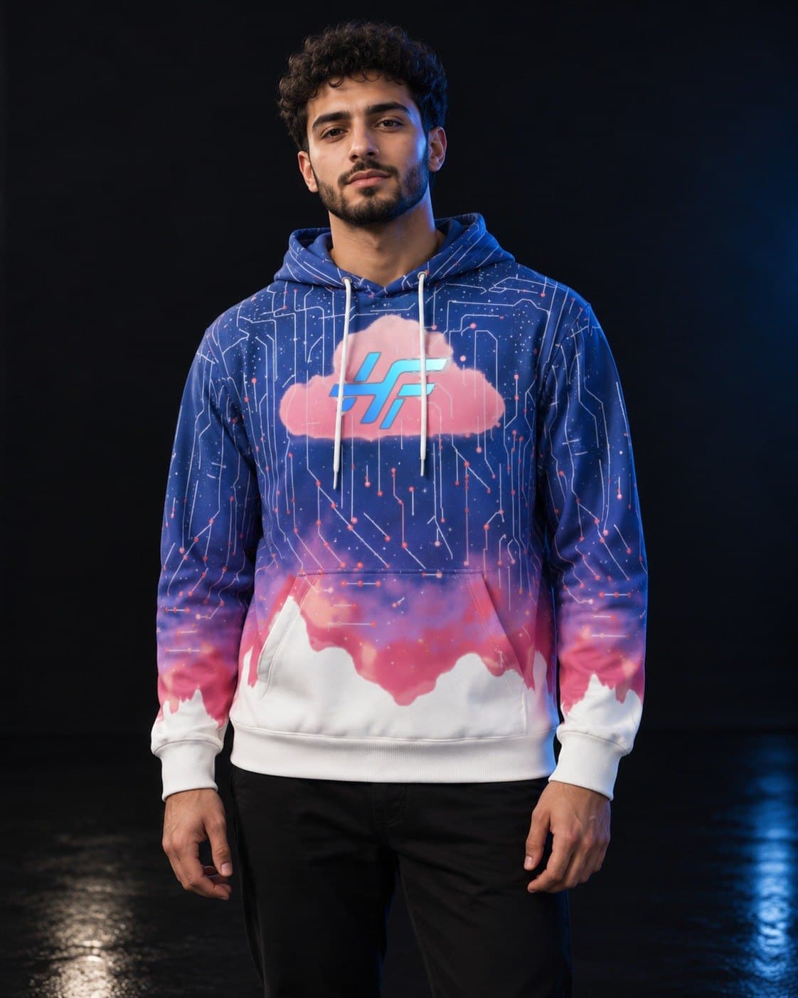 A man with a trimmed beard in a dark studio, wearing the Cloud Hoodie
