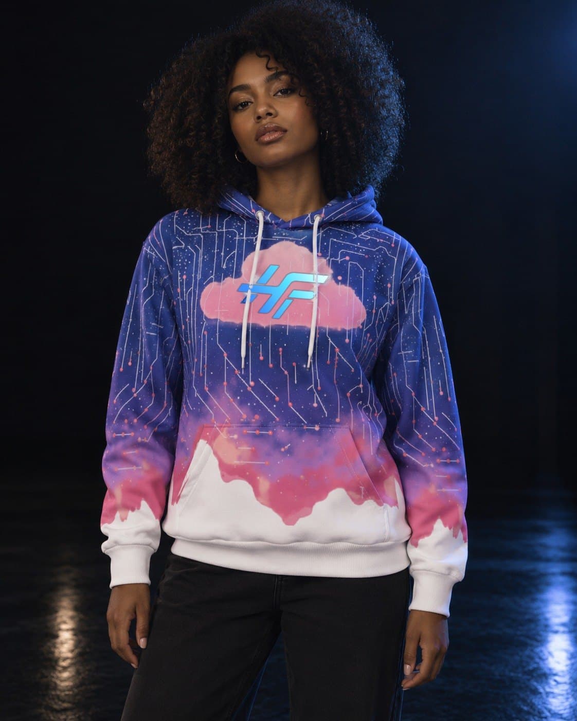 A woman with natural curls in a dark studio, wearing the Cloud Hoodie